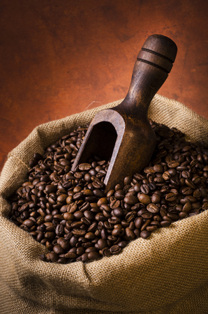 roasted coffee beans in jute sack with wooden scoop.still lifeの写真素材