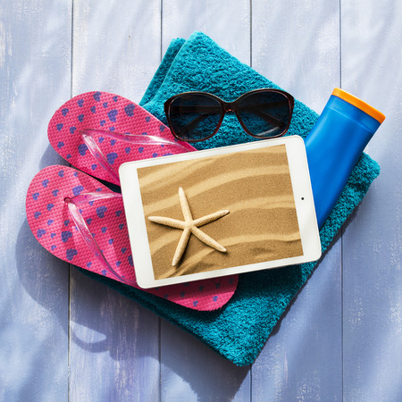 accessories for a relaxing beach holiday arranged on a blue backgroundの写真素材