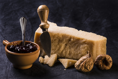 hard cheese with dried figs, walnuts and bowl with fruit jamの写真素材