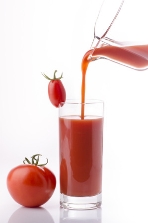 ripe tomatoes and fresh tomato juice to drink in a glassの写真素材