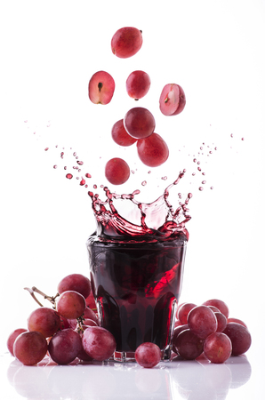 bunch of red grapes and fresh grape juice on a white backgroundの写真素材