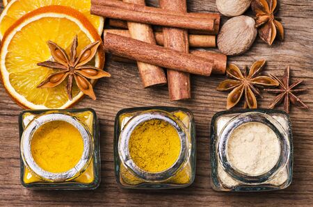 Still life. Top view composition
with different kinds of spices with bright colors including ginger, turmeric and curry on the rustic wooden tableの写真素材