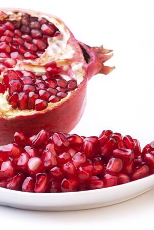 closeup of ripe pomegranate seeds with a ruby red color isolated from the white backgroundの写真素材