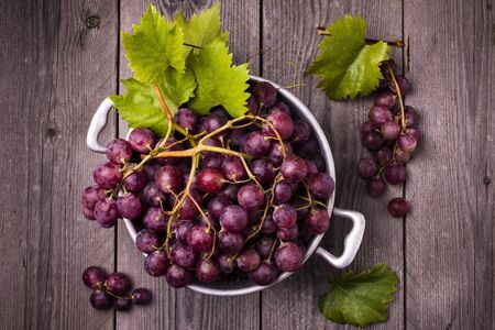 in colander vintage red table grapes with leaves .still lifeの写真素材