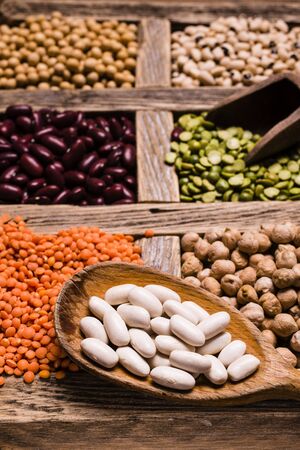 selection of dried vegetables in wooden compartments on a rustic wooden table