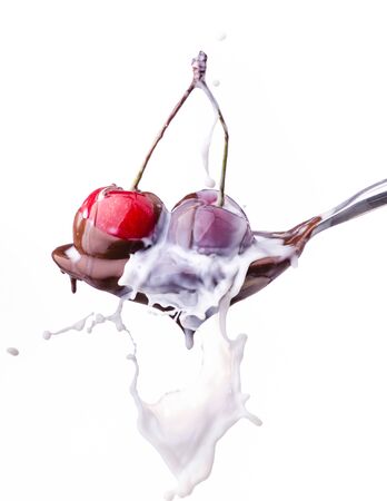 spoon with juicy cherries covered with melted dark chocolate and milk splashの写真素材