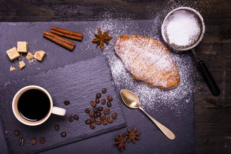 breakfast with a cup of black coffee sweetened with brown sugar and warm croissantsの写真素材