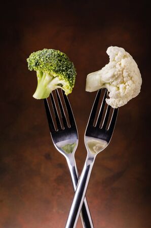 forks with parts of cabbage and broccoli in the foregroundの写真素材