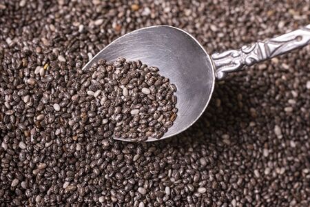 on a gray structure, top view, a pile of chia seeds, with spoon, close-up viewの写真素材