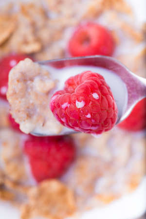 breakfast with brown rice flakes, milk and fresh raspberries