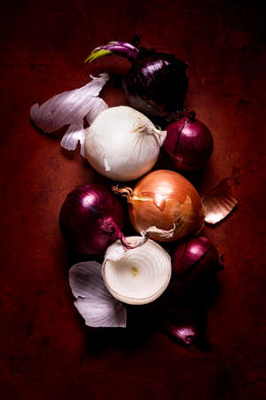 some red, white and golden onions on textured background with top view. Still lifeの写真素材