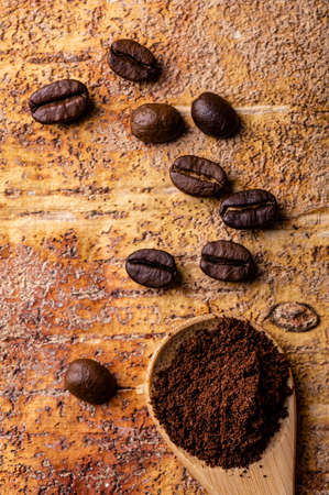 in the foreground, from above, of the coffee beans and the coffee powder in the spoon.の写真素材