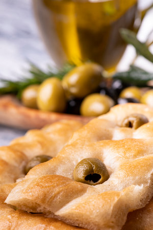 in the foreground tasty Genoese focaccia with olives, in the background cruet and olives.の写真素材
