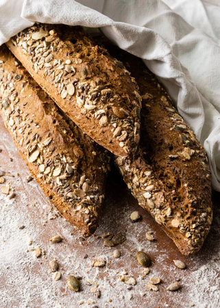 in the foreground of rustic bread with seeds and grainsの写真素材