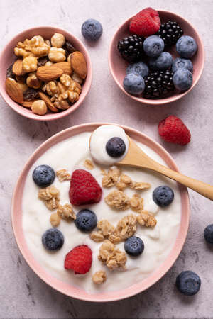 Concept of healthy nutrition. Food for breakfast, top view, a bowl with low-fat yogurt, crunchy oatmeal, dried and fresh fruit.の写真素材
