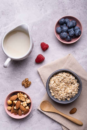 Concept of healthy nutrition. Food for breakfast, top view, a bowl with whole and organic oat cereals, dried fruit, fresh fruit and oat drink.の写真素材