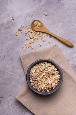 In the foreground, with an overhead view, a bowl of wholegrain, organic oatmeal.