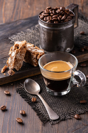 in the foreground, a glass with espresso coffee and some almond biscuits. Still lifeの写真素材
