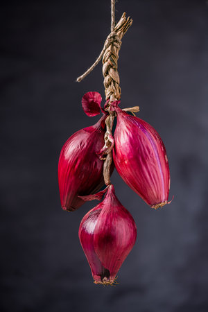 In the foreground some woven Tropea onions hanging from a rope.の写真素材