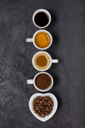 View from above. Some types of coffee in various cups arranged in a vertical row on a black backgroundの写真素材