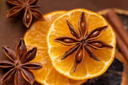 top view, in the foreground, a star of star anise laid on orange slicesの写真素材