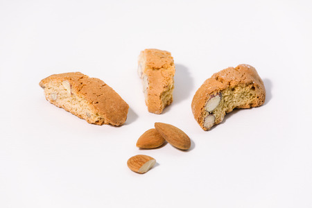 Three almond cantuccini and three almonds on white backgroundの写真素材