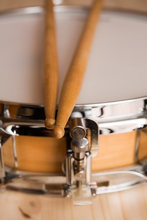 Drum sticks over a snare drum with wood backgroundの写真素材