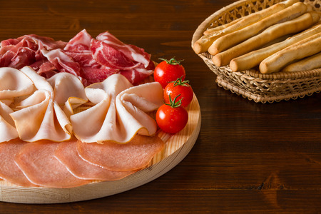 Italian cutting board and bread-sticks on a wicker basketの写真素材