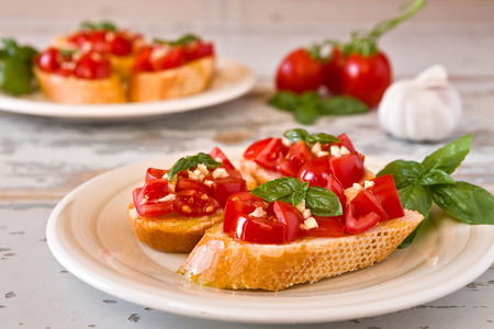 Closeup of Italian bruschetta with tomato, basil and garlic on a plateの写真素材