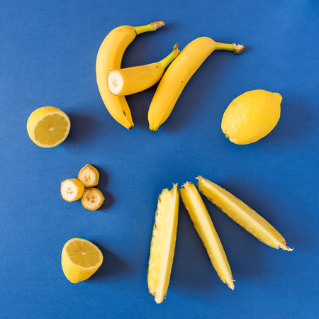 Fresh yellow toned fruits over a blue backgroundの写真素材