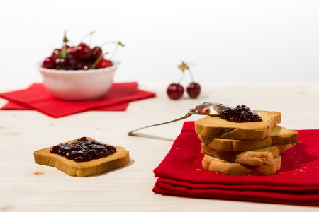 Rusk with cherry jam and cherry fruit on backgroundの写真素材