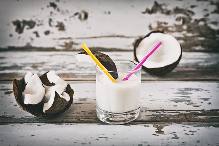 Coconut and coconut milk in a glass over a wooden backgroundの写真素材