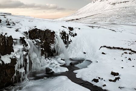 Closeup of waterfall in front of Kirkjufell mountain at sunset in Snaefellsnes peninsula, Icelandの写真素材