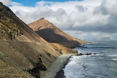 Krossnesfjall mountain on the eastside of Iceland in front of the oceanの写真素材