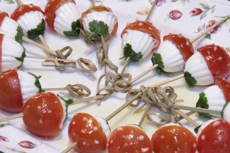 Photographs of some  skewers of cherry tomato, cheese and parsley.の写真素材