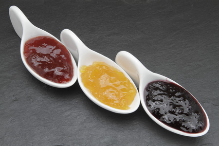 samples of peach jam, strawberries and cherriesの写真素材