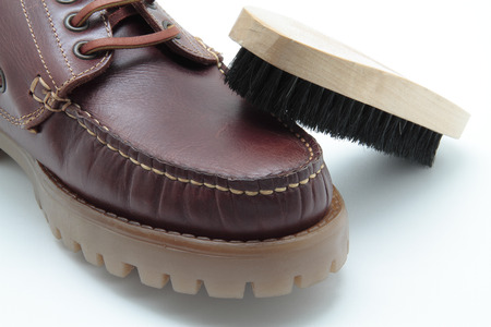 shoe and shoe brush on white background