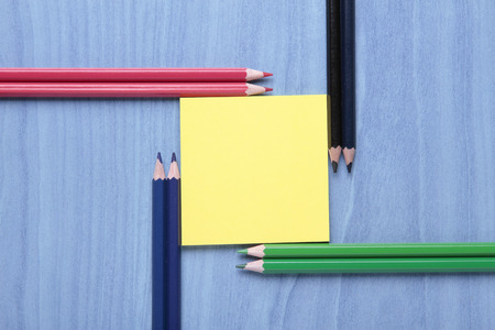 crayons and yellow notes on blue backgroundの写真素材