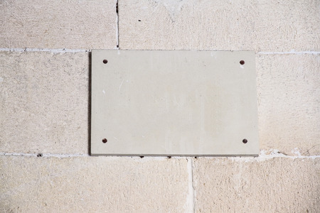 foreground of a empty plaque on a wall of stoneの写真素材