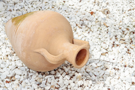 decorative amphora on a ground covered with white stonesの写真素材