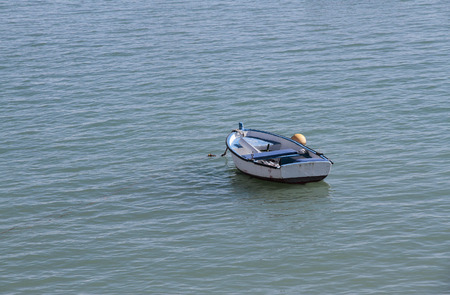 horizontal view of a small wooden boat anchored in the seaの写真素材
