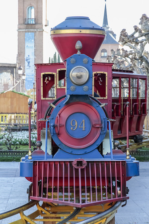 foreground of an attraction train red and blue color on cervantes square in the city of alcala de henaresのeditorial素材