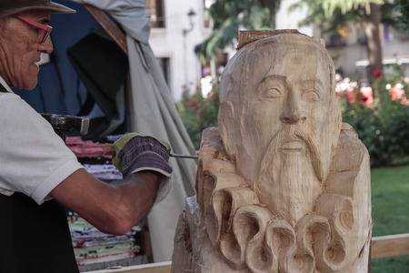 ALCALA DE HENARES, MADRID, SPAIN - OCTOBER 10, 2016: sculptor carving in wood the bust of the famous writer miguel de cervantes during the celebration of a medieval festival in the city of alcala de henresのeditorial素材