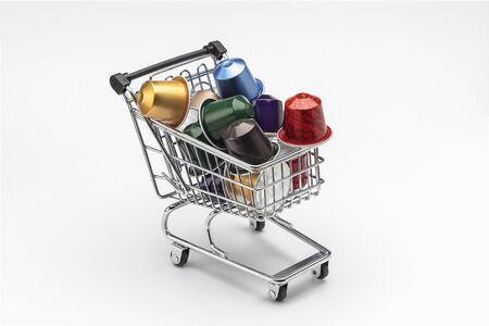 horizontal view of several coffee capsules of espresso in a shopping cart isolated on white backgroundの写真素材