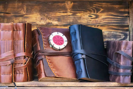 horizontal view of handmade notebooks with leather cover on bookshelfs made with wooden boxes....