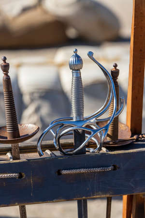 foreground in vertical view of the hilts of some rapier swords from the 16th and 17th centuries....