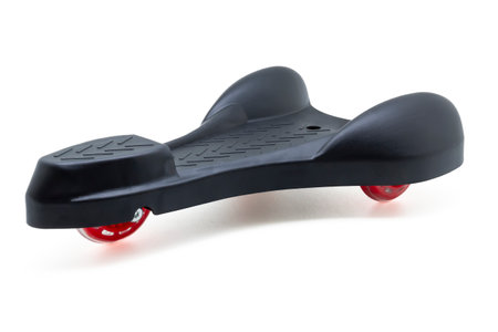 horizontal view of a black color roller skate with three red wheels isolated on white background