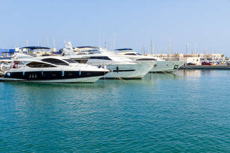 horizontal view of the marina with three yachts docked in the foregroundの写真素材