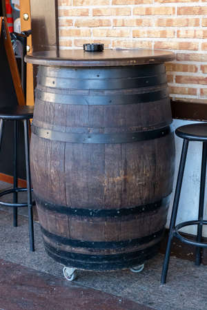 vertical view of a large wooden barrel used as a table on the outside of a restaurant.copy spaceの写真素材