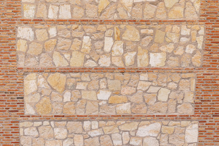 horizontal view of stone wall texture background separated by three rows of bricksの写真素材